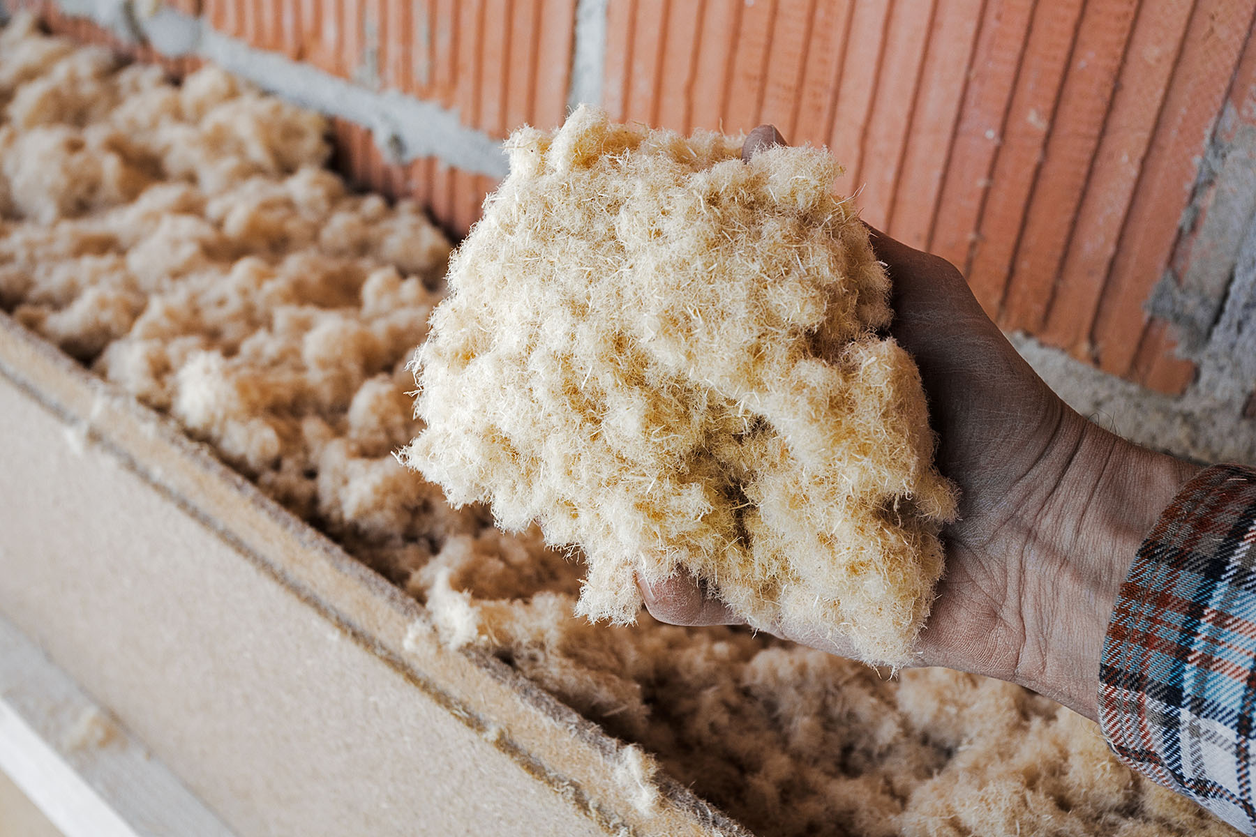 dry wood fiber blown-in in front of a brick masonry